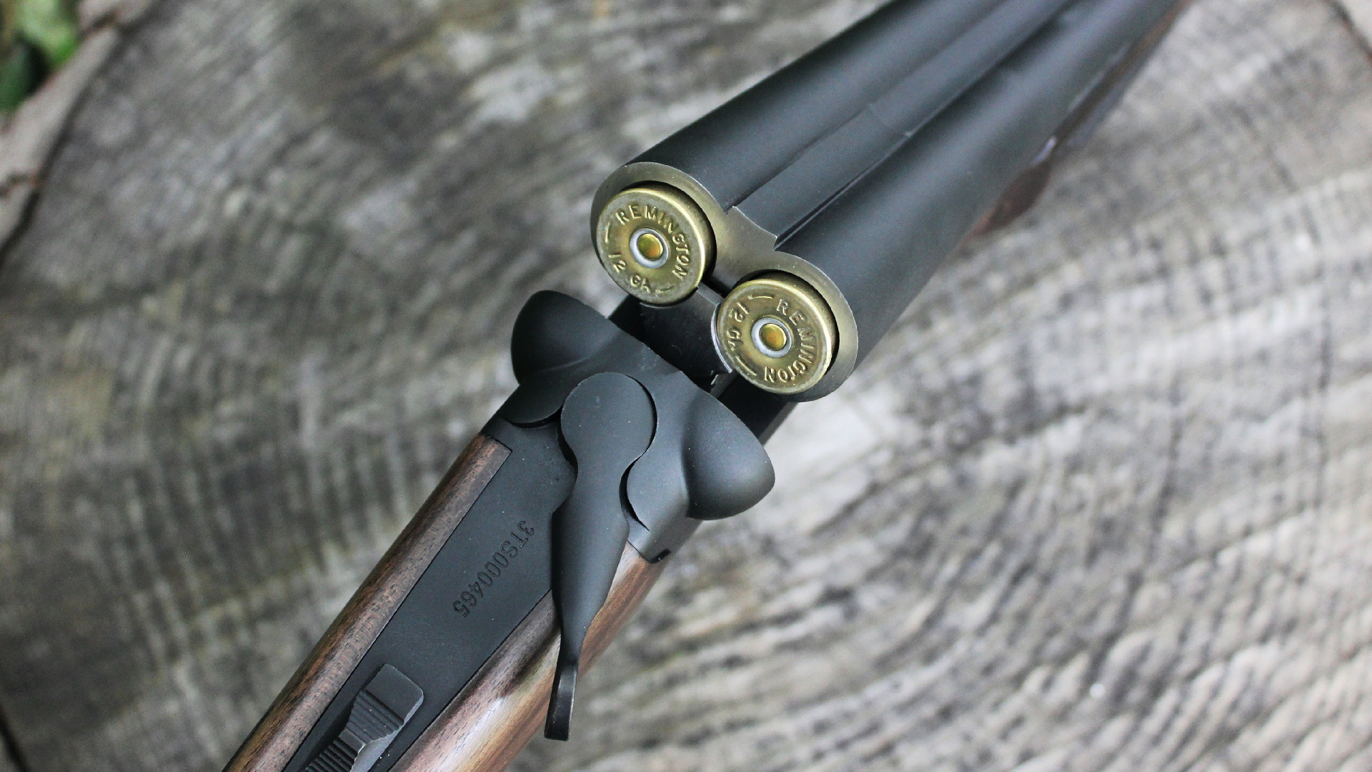Heritage Badlander shotgun open loaded shotshells brass gun closeup details log background outdoors