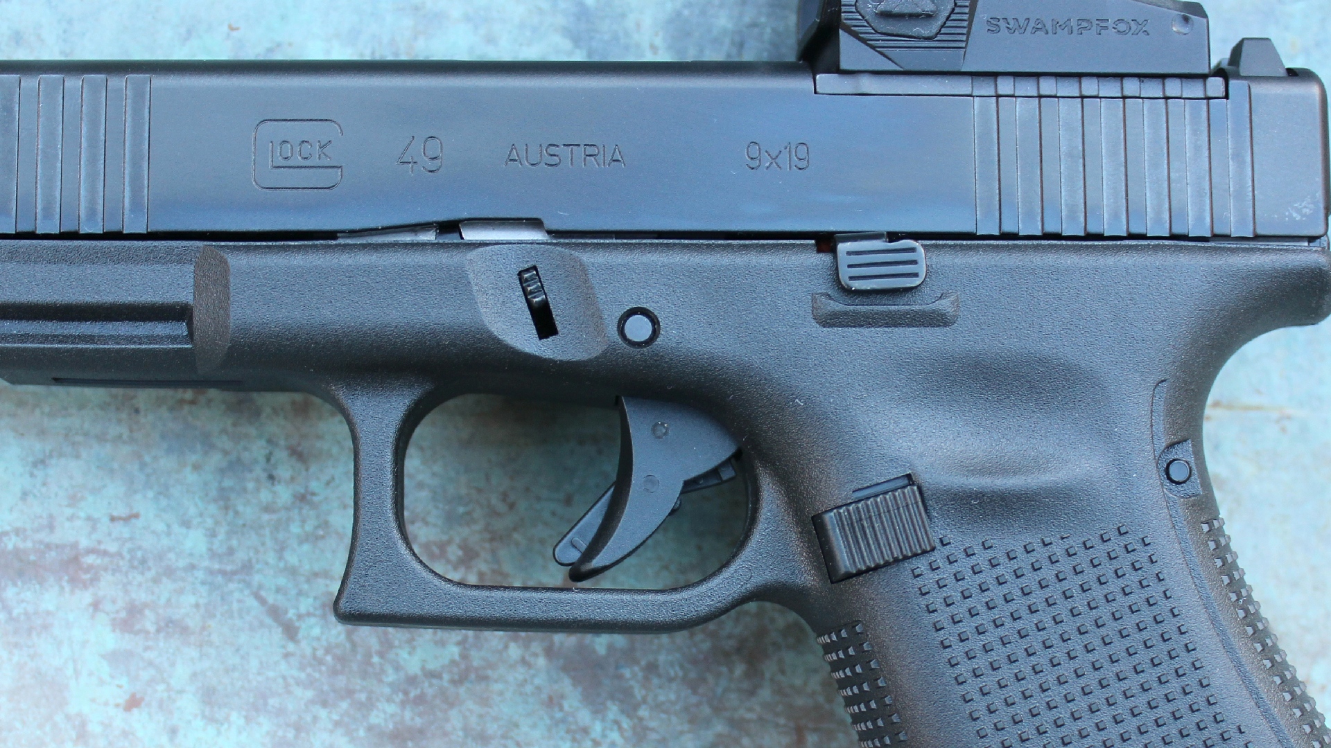 Glock G49 Gen5 MOS left-side closeup controls trigger magazine release slide lock takedown lever black gun 9 mm stippling