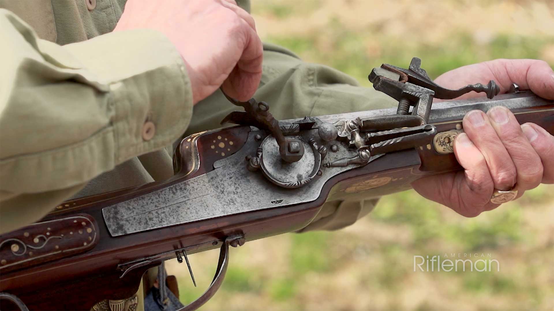 Man winding the wheel mechanism on an early wheellock sporting carbine.