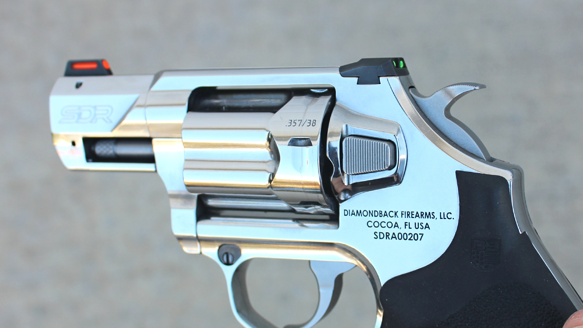 Diamondback Firearms SDR revolver stainless steel gun left-side view illustrating serrated cylinder release button on left side of frame rear of fluted cylinder