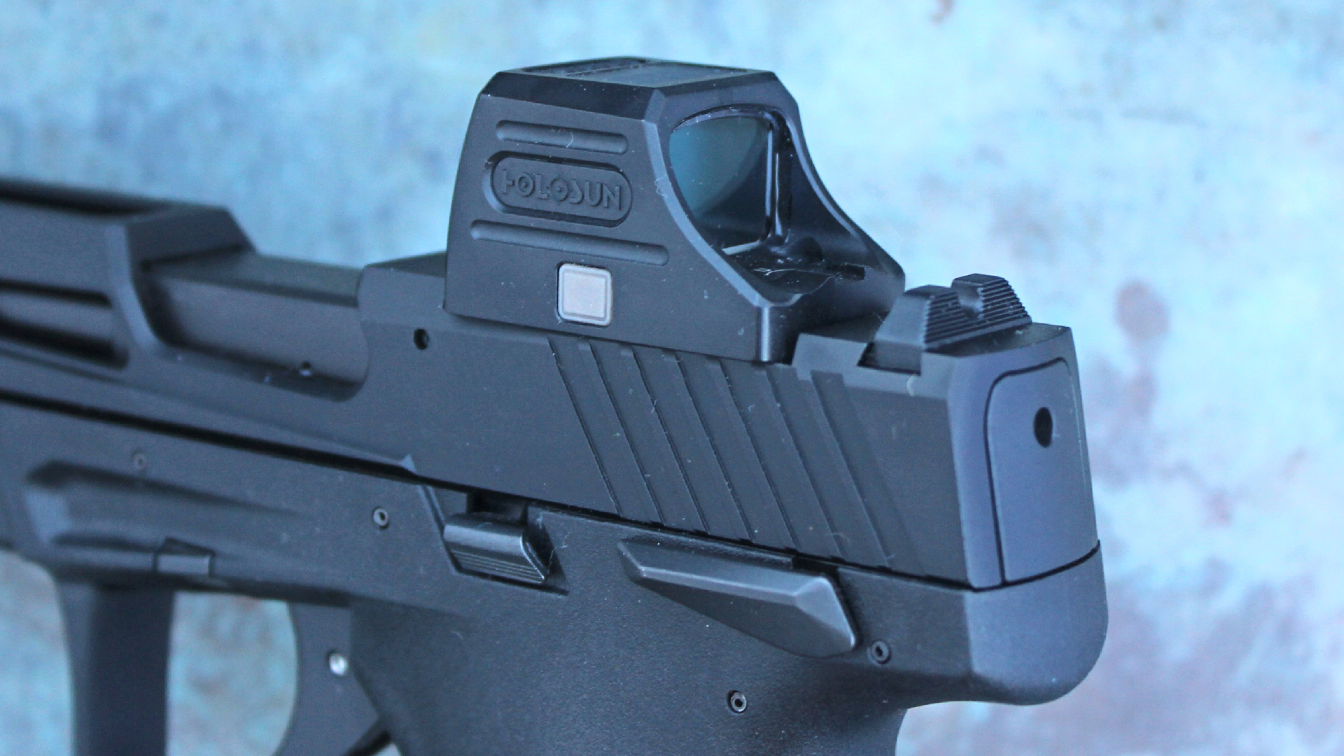 Taurus TX22 slide, close-up, detail of optics cut with HOLOSUN optics attached to black pistol