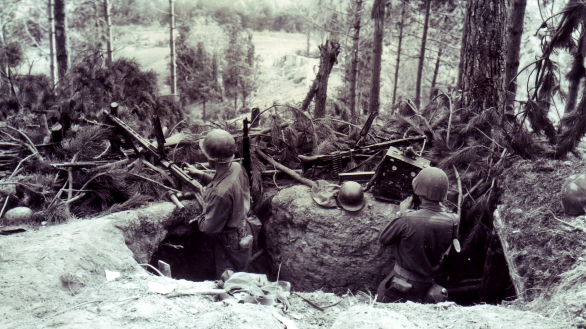 A captured hornet’s nest on the Gothic Line in Italy: GIs examine a pair of MG42s and a radio connection in a German machine gun nest. September1944. Photo courtesy of National Archives and Records Administration, NARA.