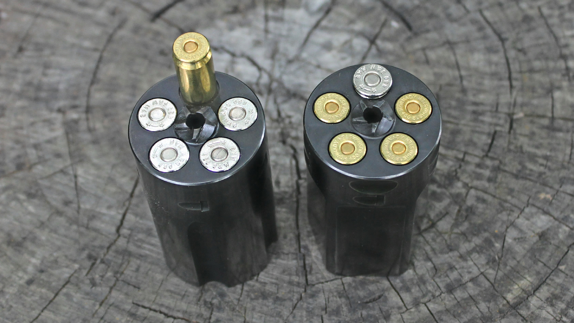 Magnum Research loaded ammunition cylinders shown on log