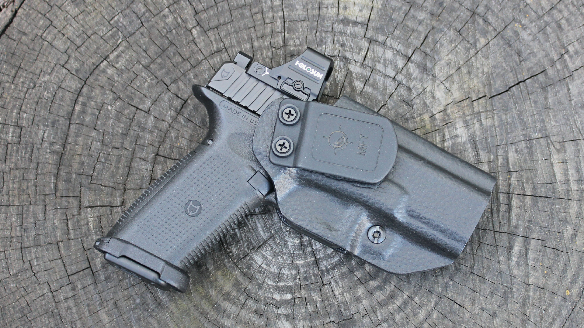 Lone Wolf Timberwolf 19X pistol black with holosun red-dot shown in leather-wrapped holster on log