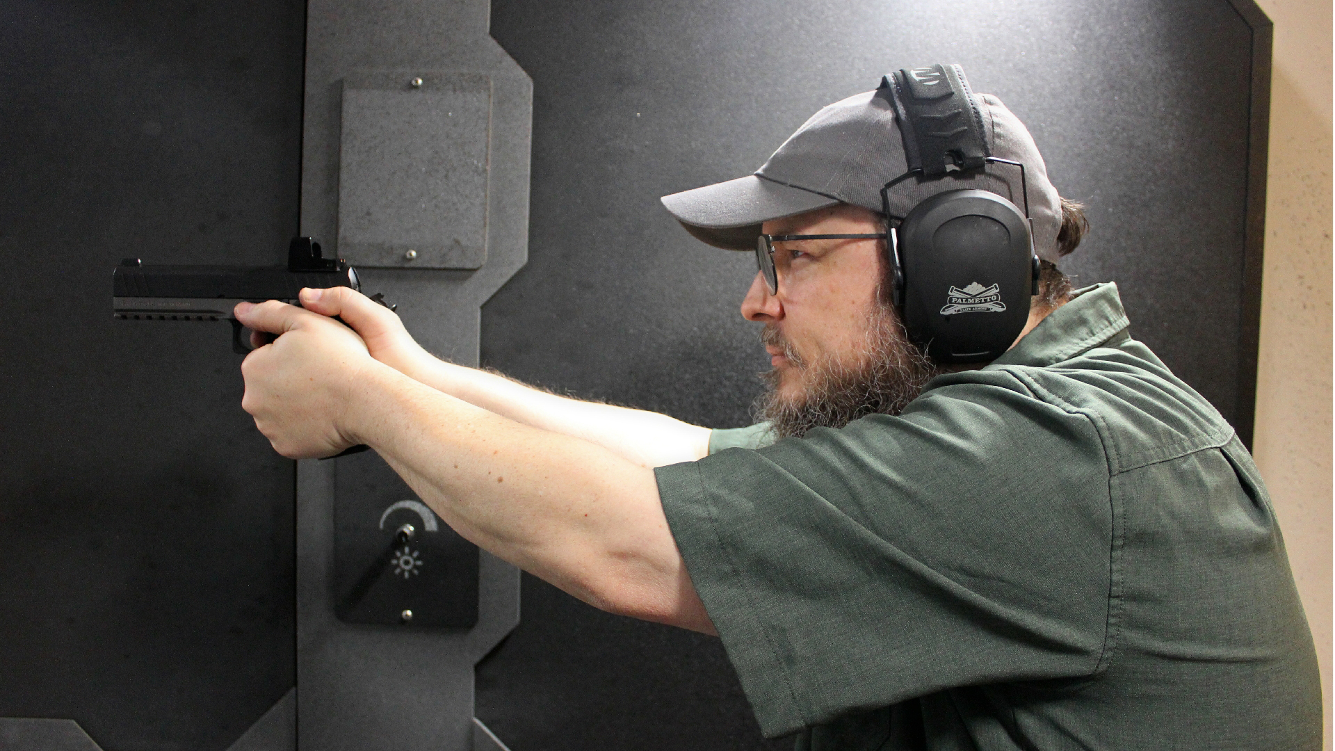 B. Gil Horman, author, seen left-side view with protective gear shooting indoors with EAA Corp Girsan Witness2311S Match 9 mm pistol