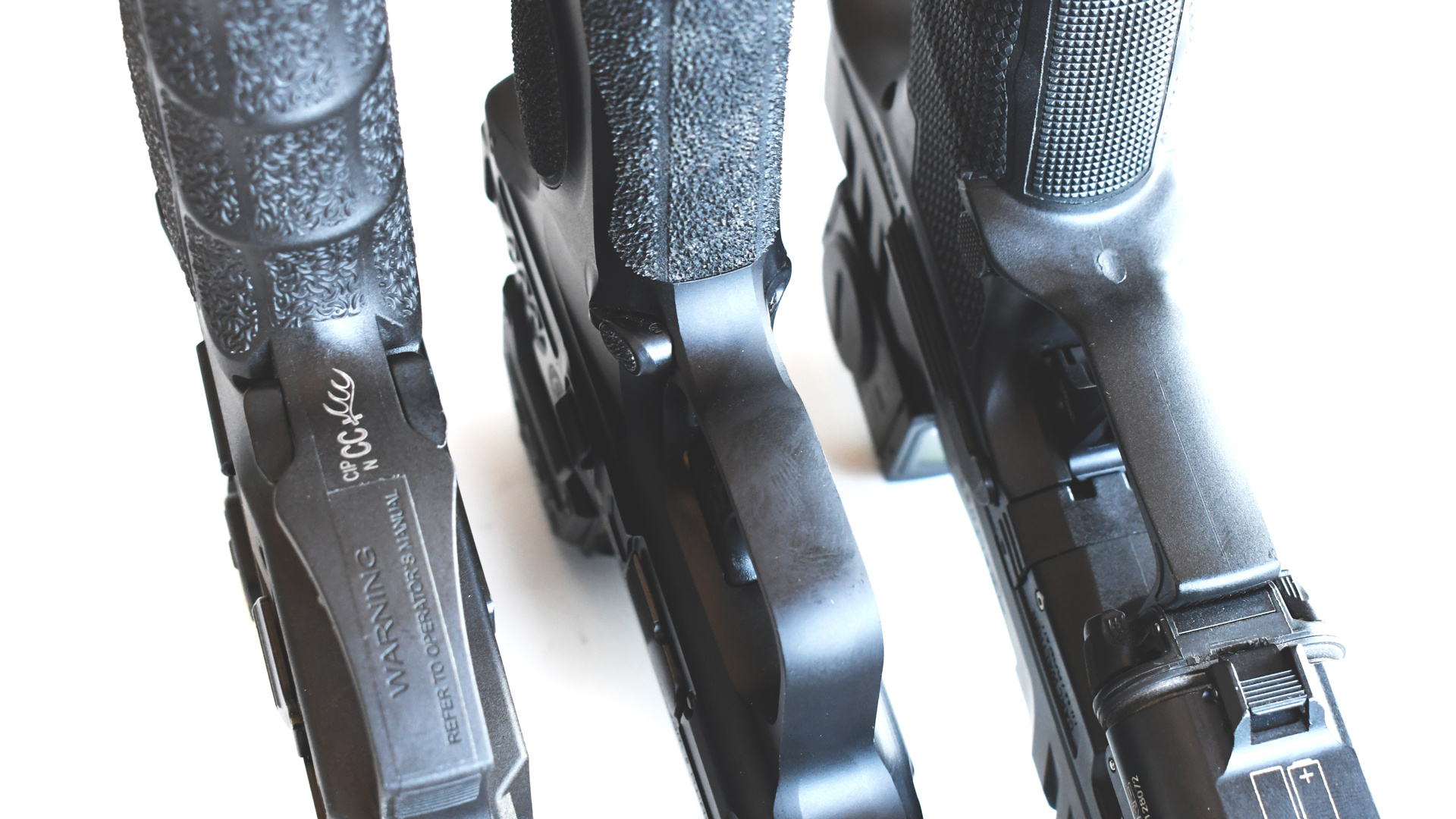 Three pistol frames grips side-by-side comparison gun parts plastic black contour texturing