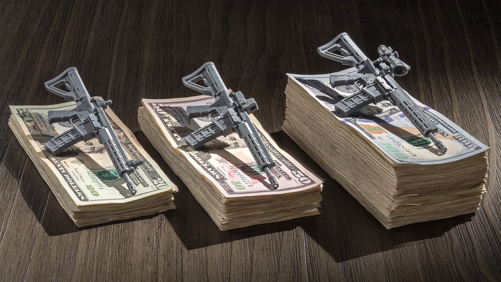 rifles on stacks of money